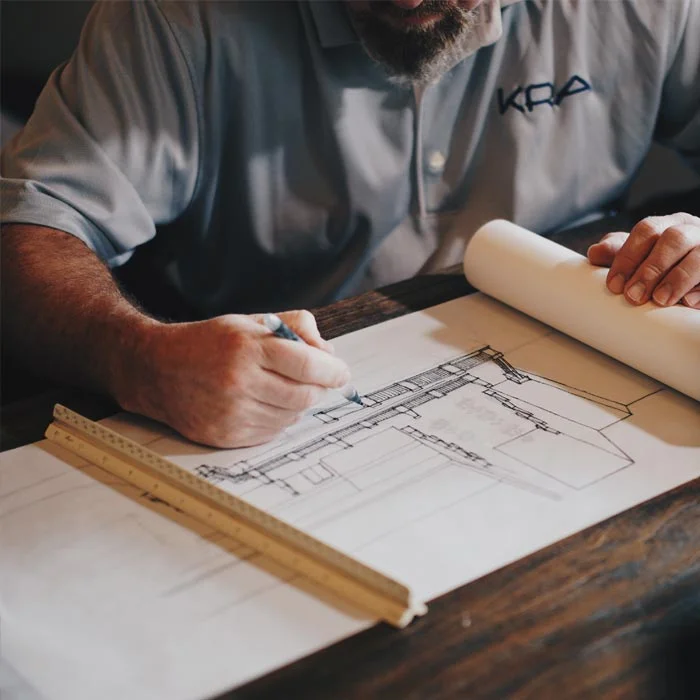 Engineer drafting over technical drawings